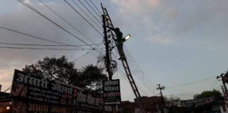 बिजली विभाग में लापरवाही जारी चलती लाइन को ठीक करता मजदूर